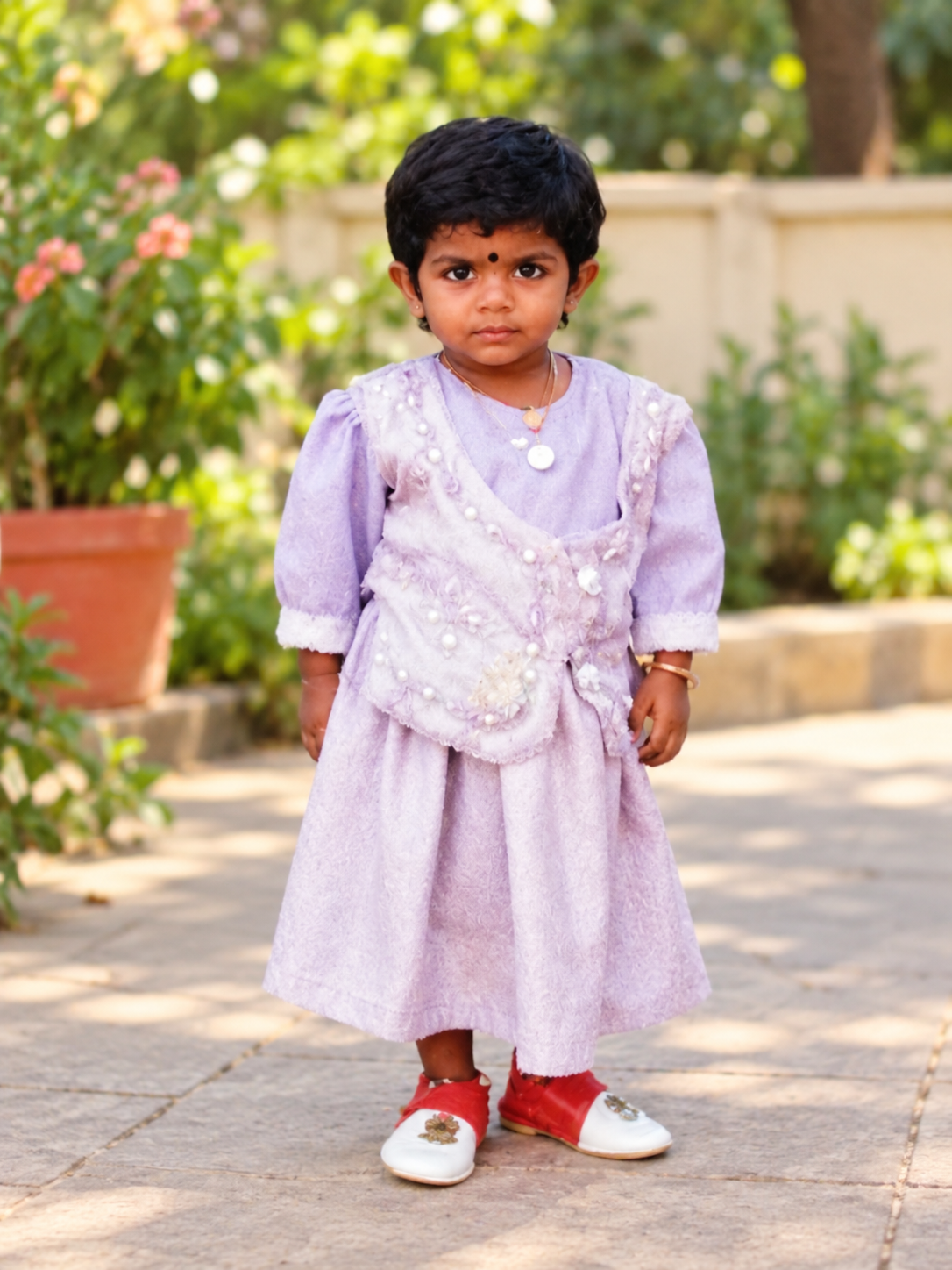 Indira as a child in a lavender dress